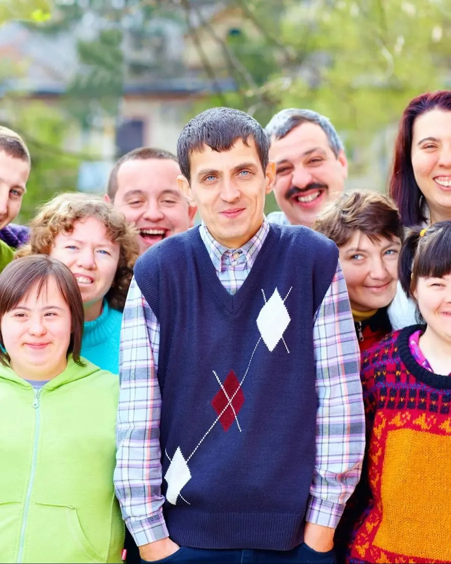 Un groupe de résidentes et résidents réunis dehors, tout sourire, bras dessus bras dessous
