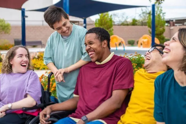 Un groupe de résidentes et résidents riant ensemble au soleil